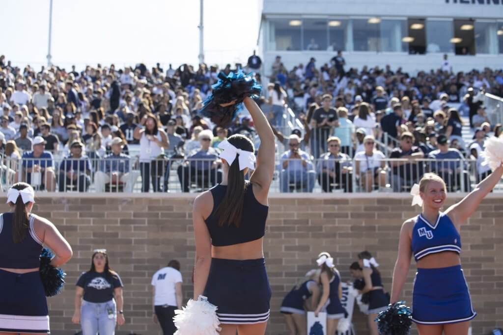 Cheerleader in front of the stands at a gane