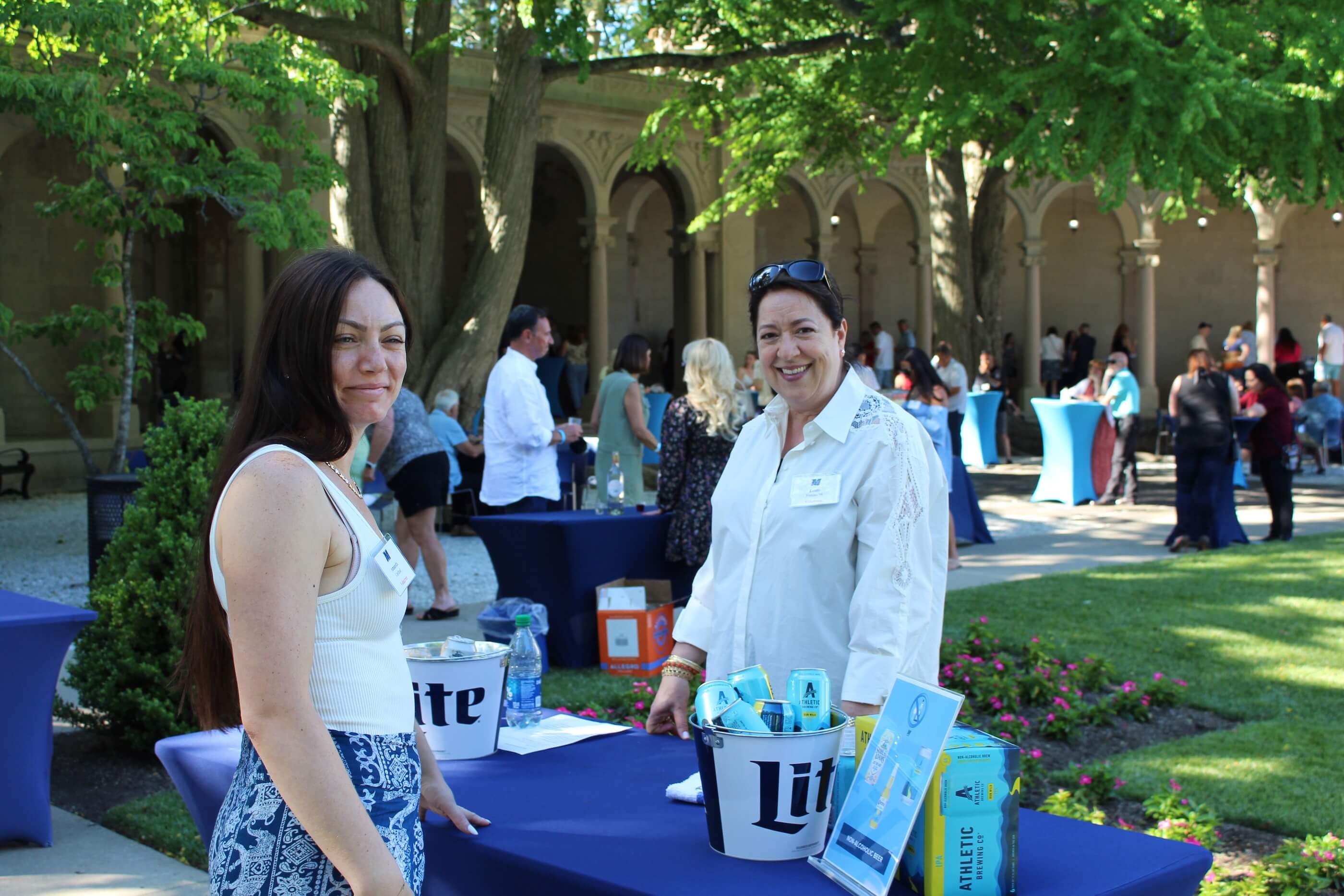 Two women standing near Athletic Brewing Company table