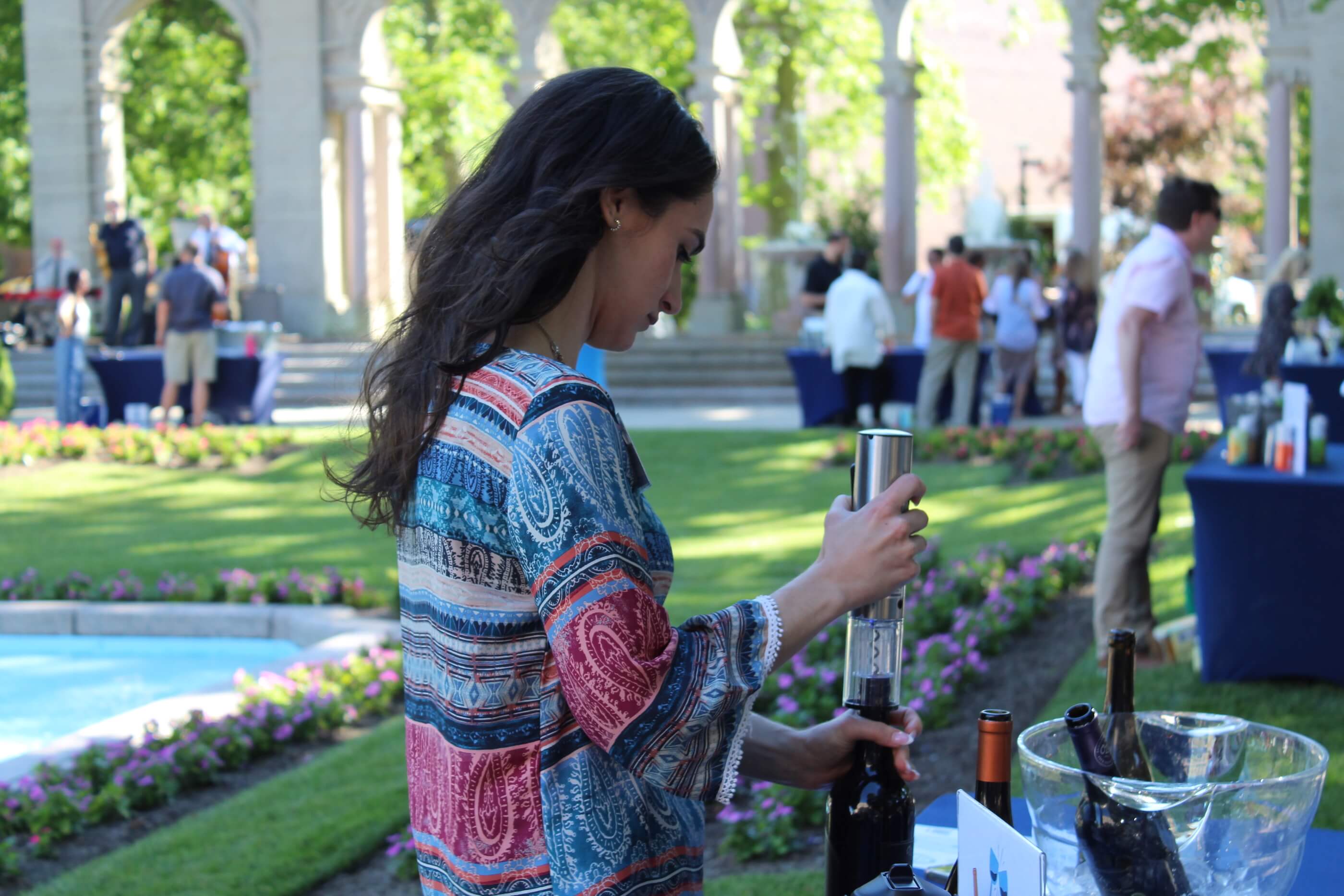 Woman uncorking a bottle of wine in Erlanger Gardens