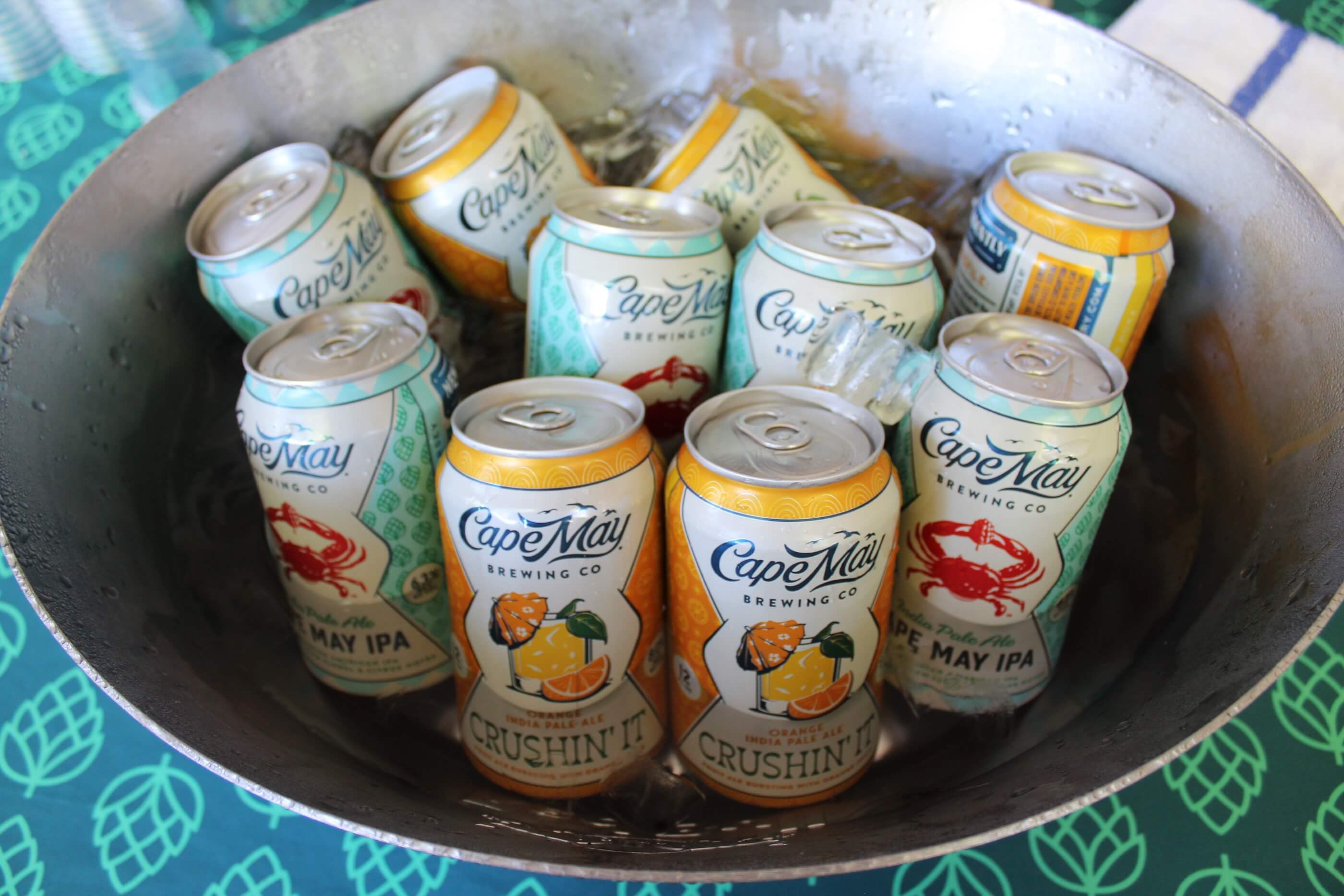 A bucket filled with ice water and beer cans from Cape May Brewing Company. Beers include "Crushin' It" and "Cape May" IPAs