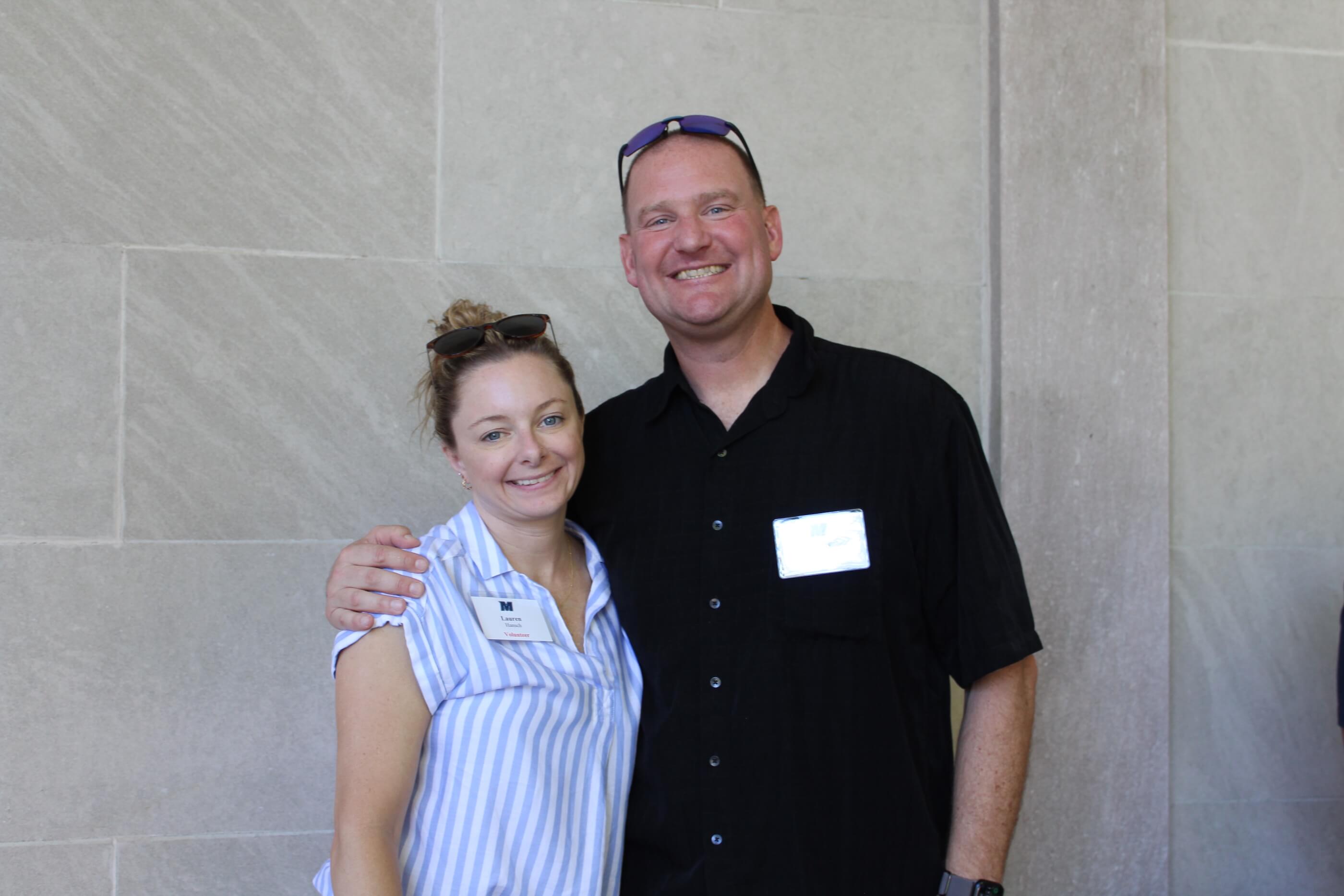 Two people posing together for a group shot near the wall in Erlanger Gardens