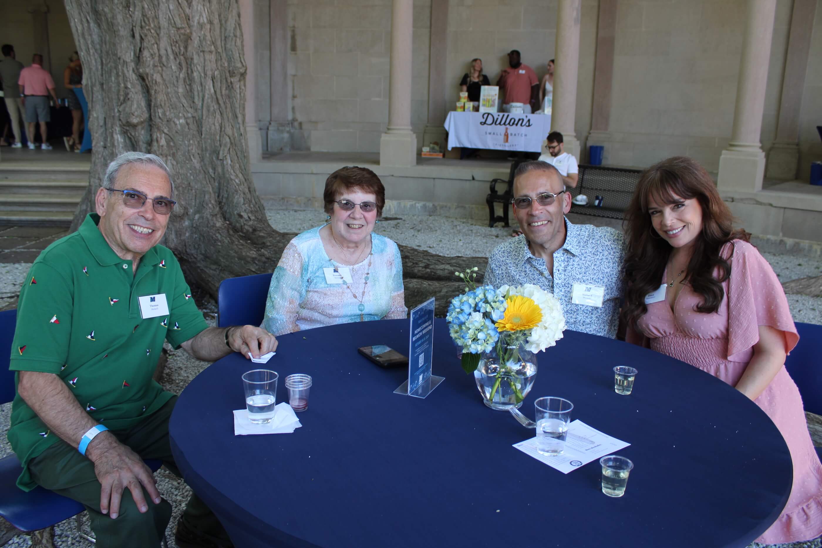 Four people sitting together at a table, with tasting glasses and glasses of water.