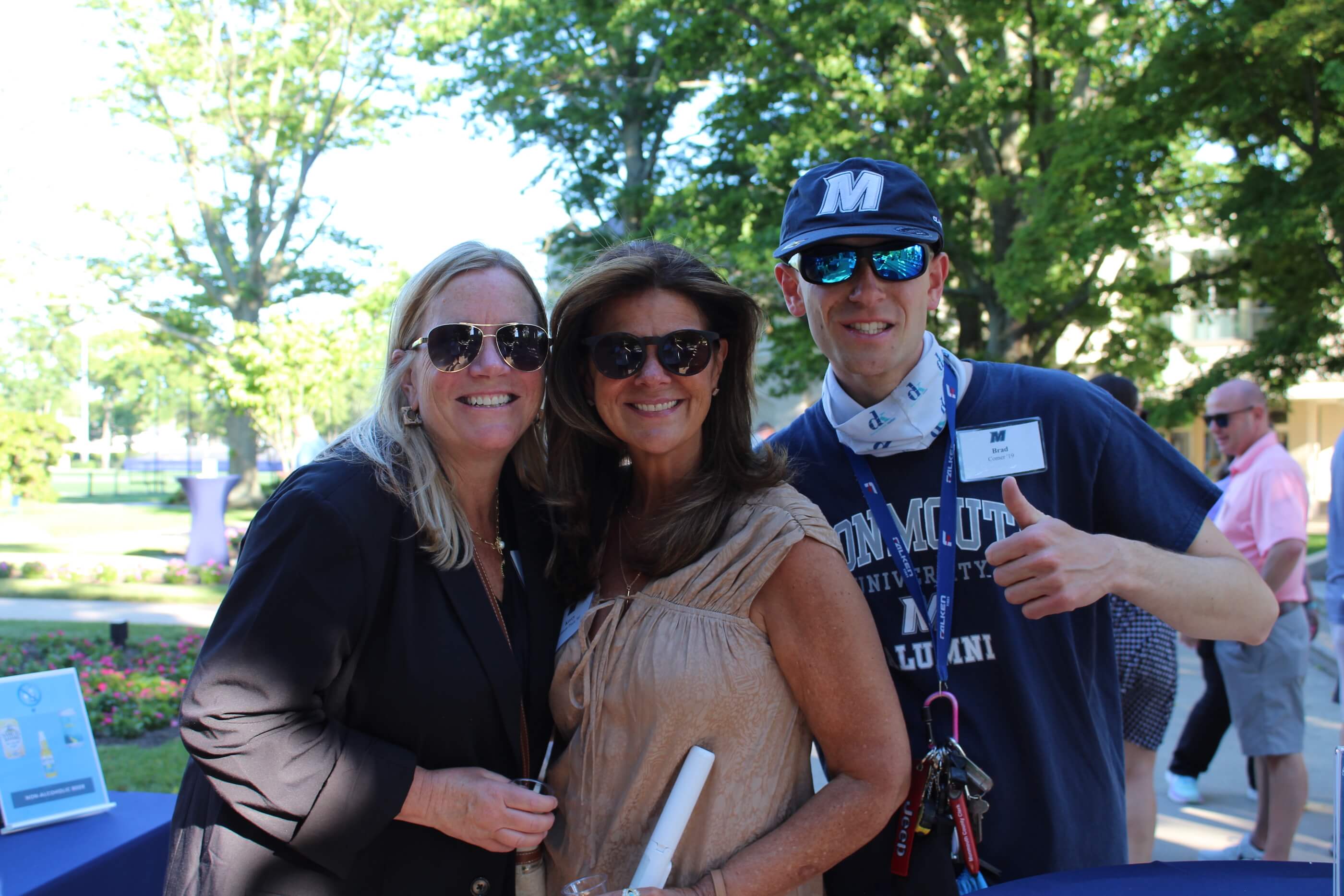 Three attendees posing for a group shot, one giving a thumbs up