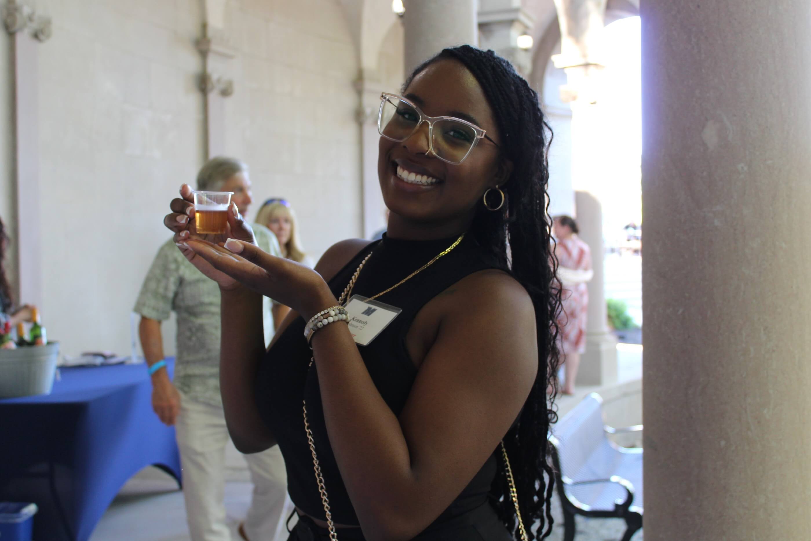 A volunteer holding a tasting glass, filled with beer, for the camera