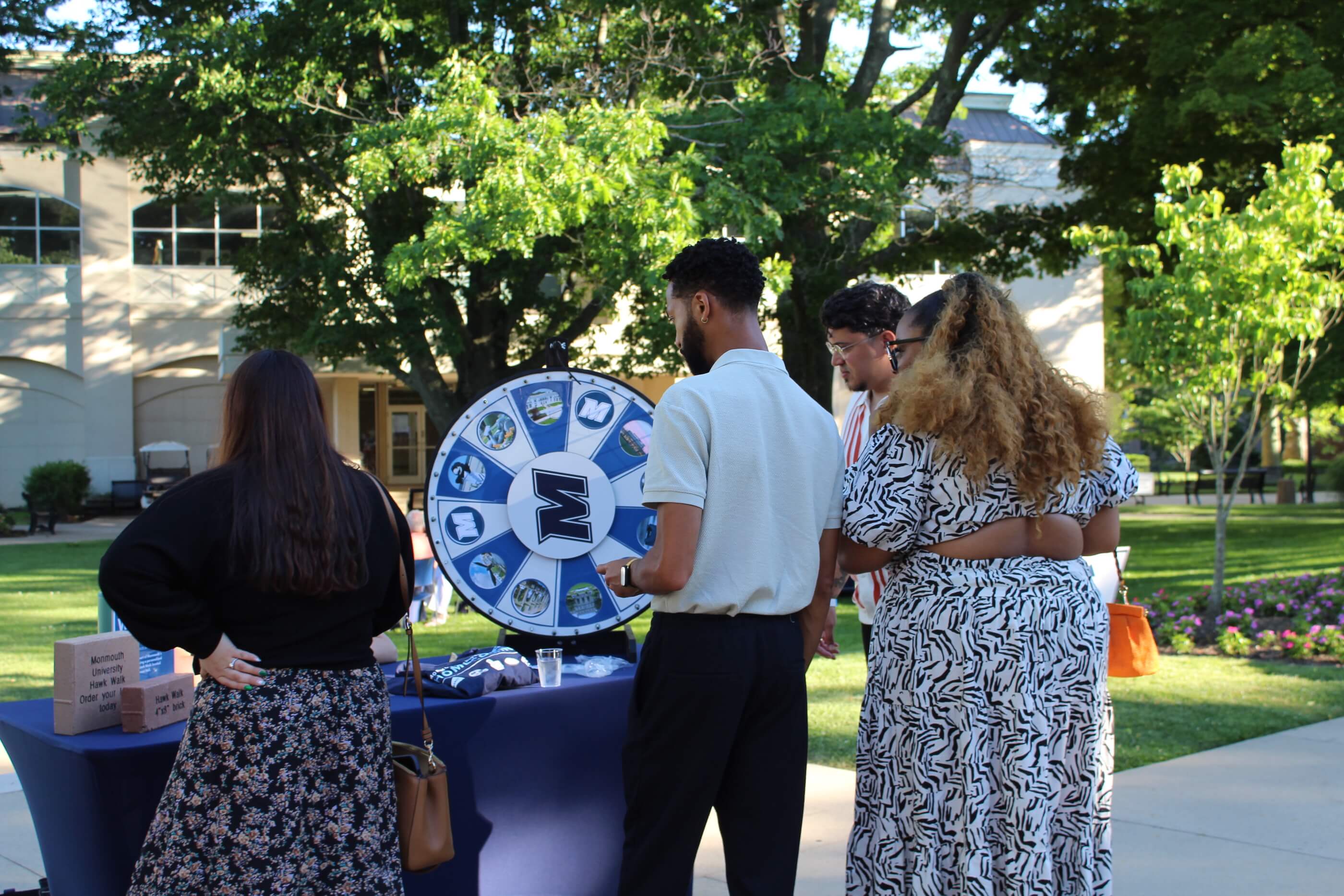 Attendees spinning a spinner picker at the Hawk Walk Brick campaign table