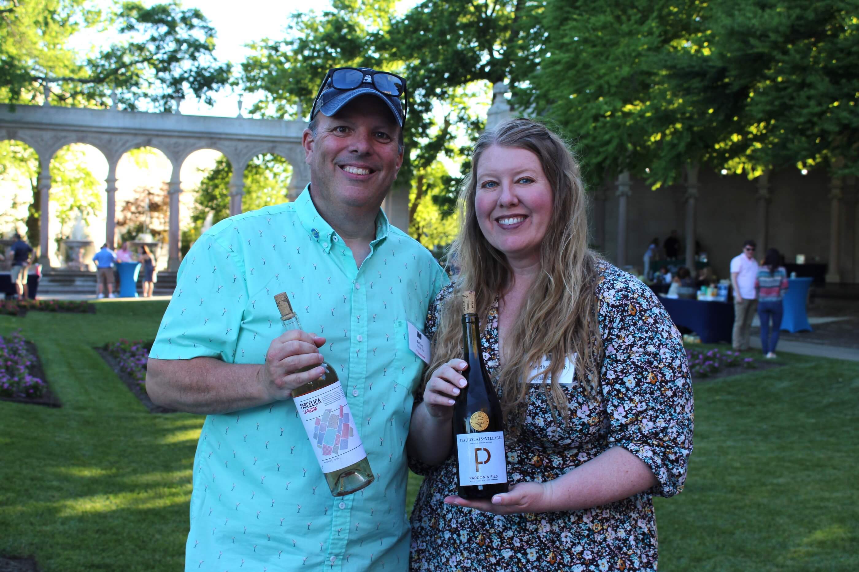 Two attendees holding up wine glasses for the camera