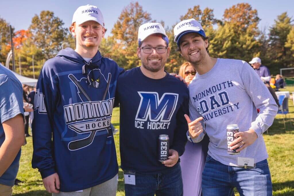 Three young alumni in Hawks hats