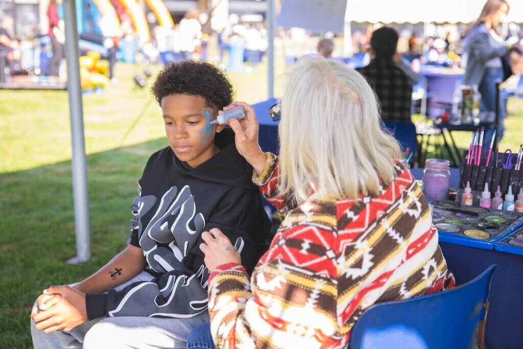 Child getting his face painted outside the stadium