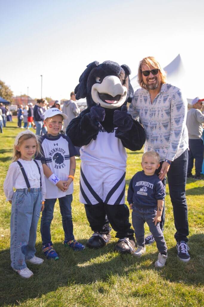 Father and his three kids posing with shadow the hawk