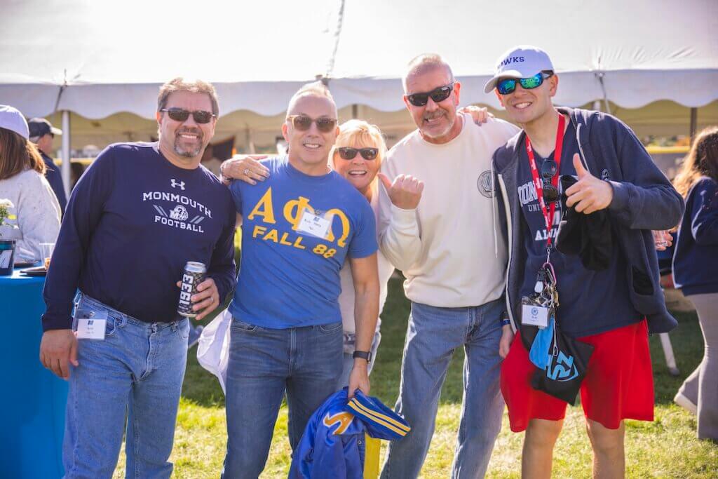 Men in fraternity gear and sunglasses smiling for camera