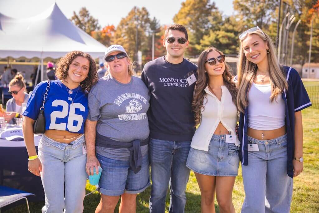 Group of alumni of various ages at the tailgate.