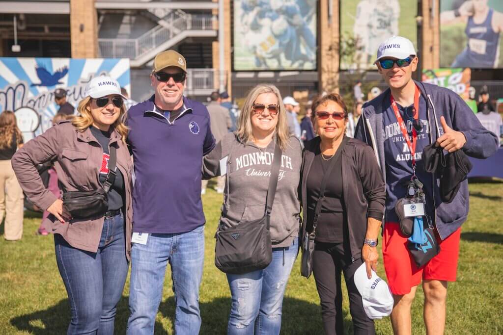 Group of adults smiling for camera outside of stadium