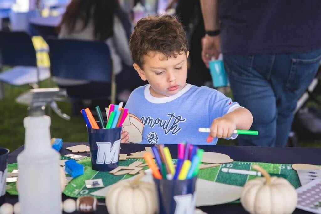 Kid playing with markers at coloring booth.