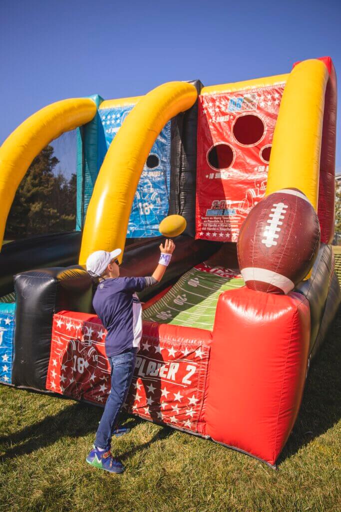 Kid throwing ball in inflatable toss game