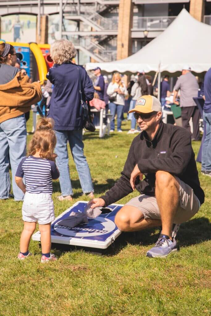 Man and young child playing cornhole