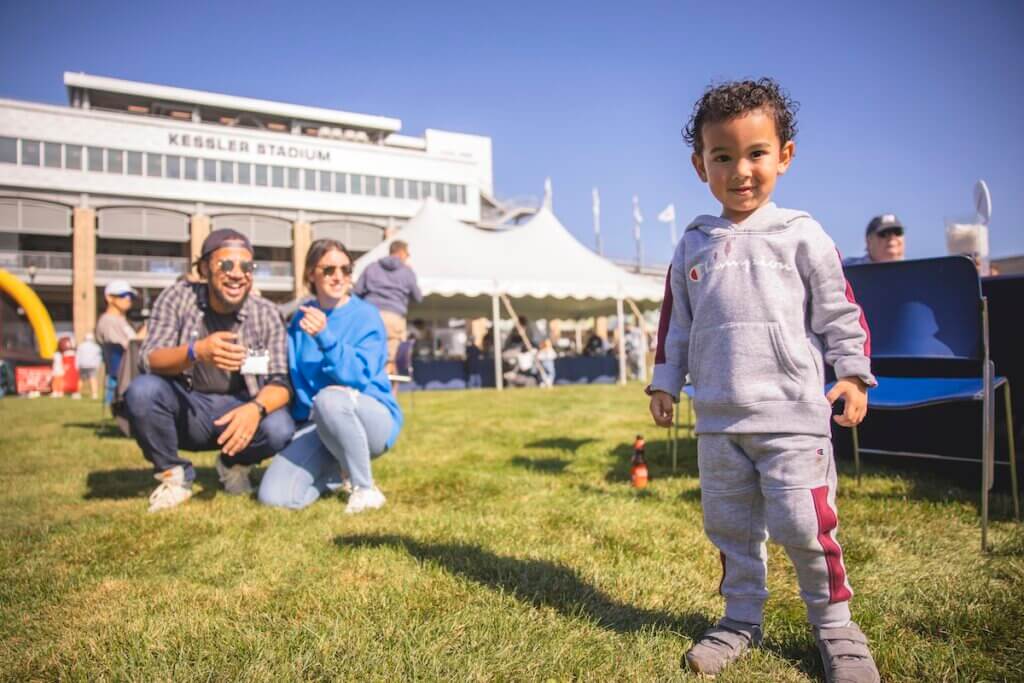 Parents watch their toddler, who is staring at the camera