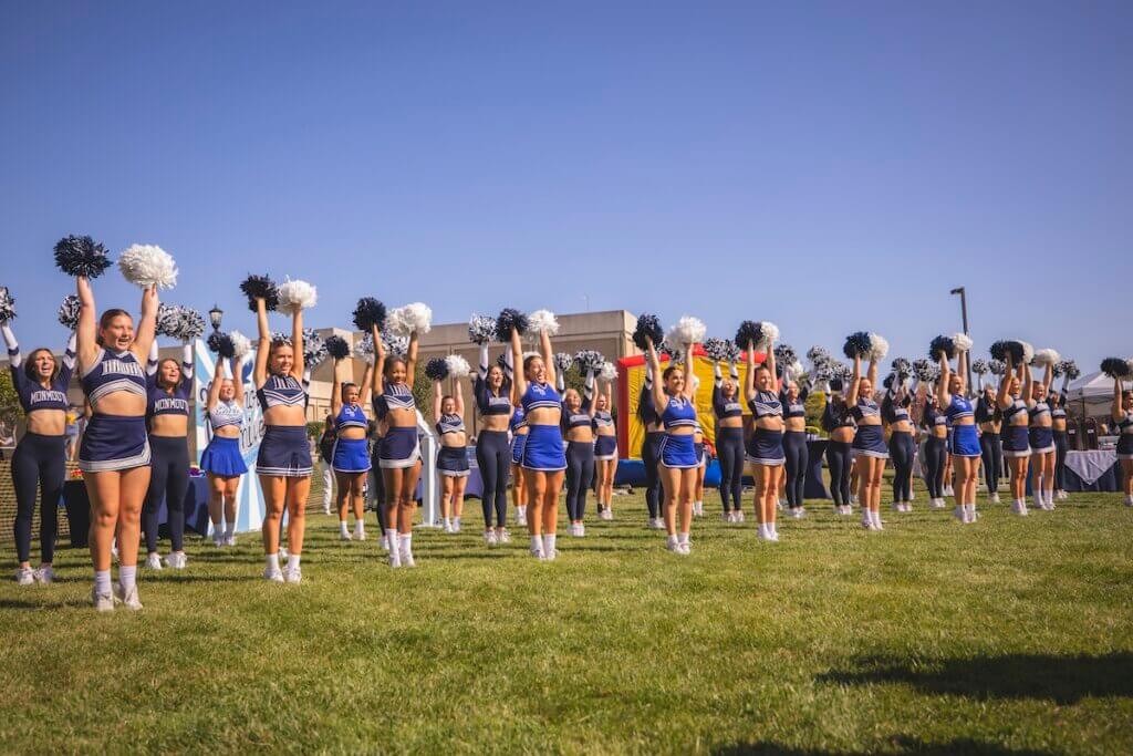 spirit squad with pom poms raised in the air