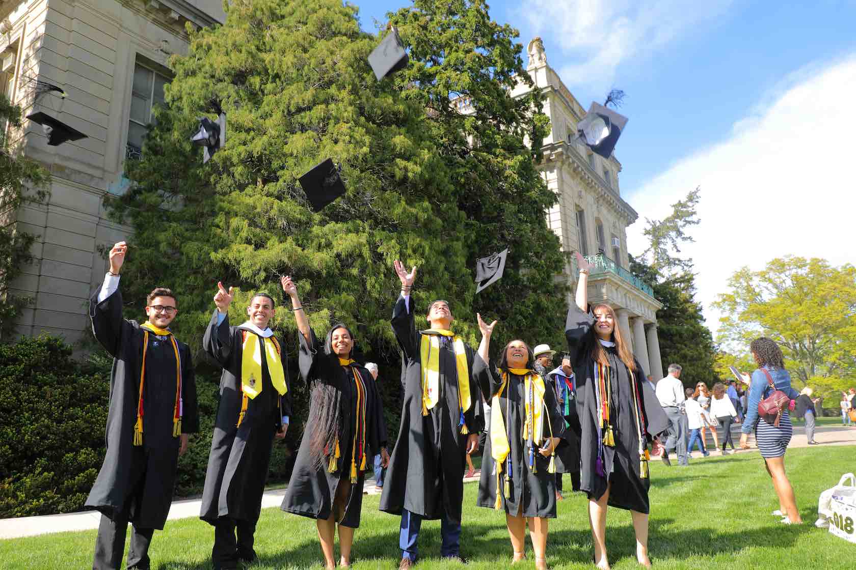 Photo of Monmouth University Graduating Students Throwing Mortarboards in the Air
