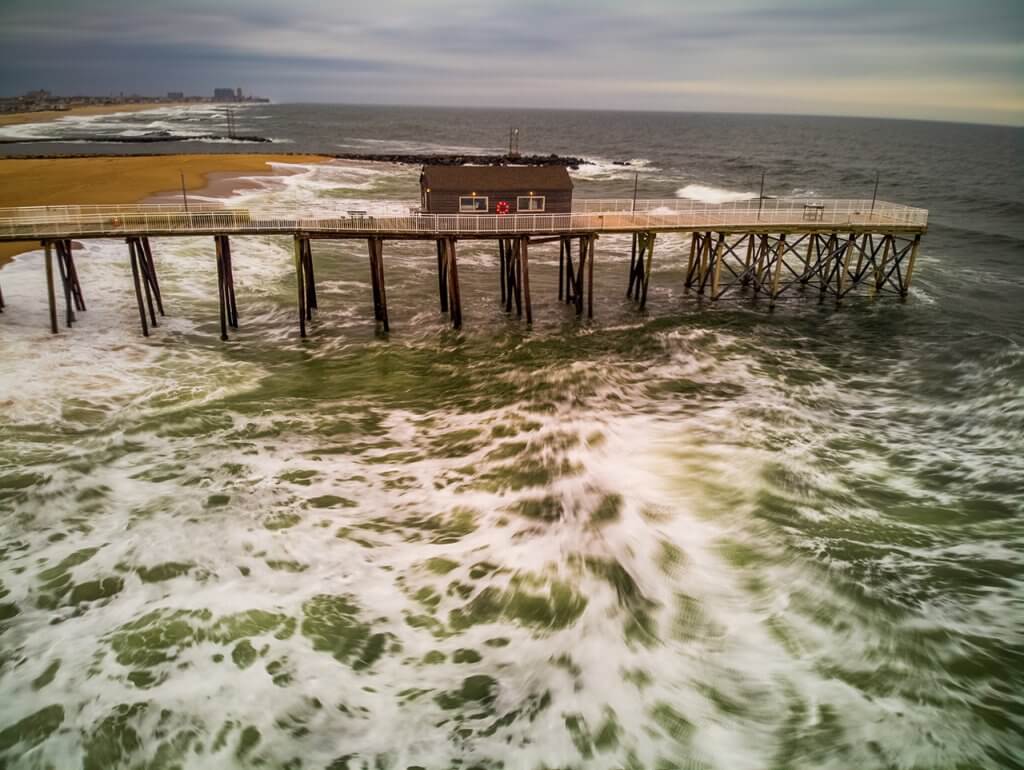 Photograph of large waves crashing at a pier along the Jersey Shore