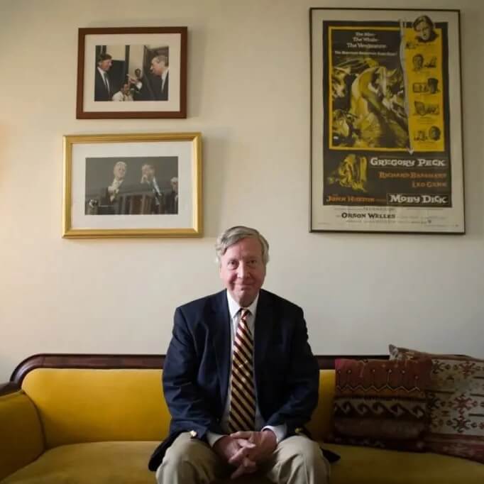 Sean Wilentz sitting on a sofa with framed photos and a movie poster for the Orson Welles adapation of Moby Dick on the wall behind him