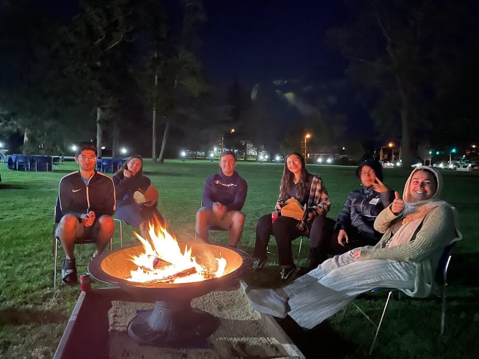 A group of students around a fire pit