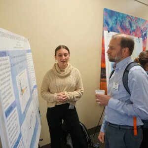 Female biology student presenting her research poster
