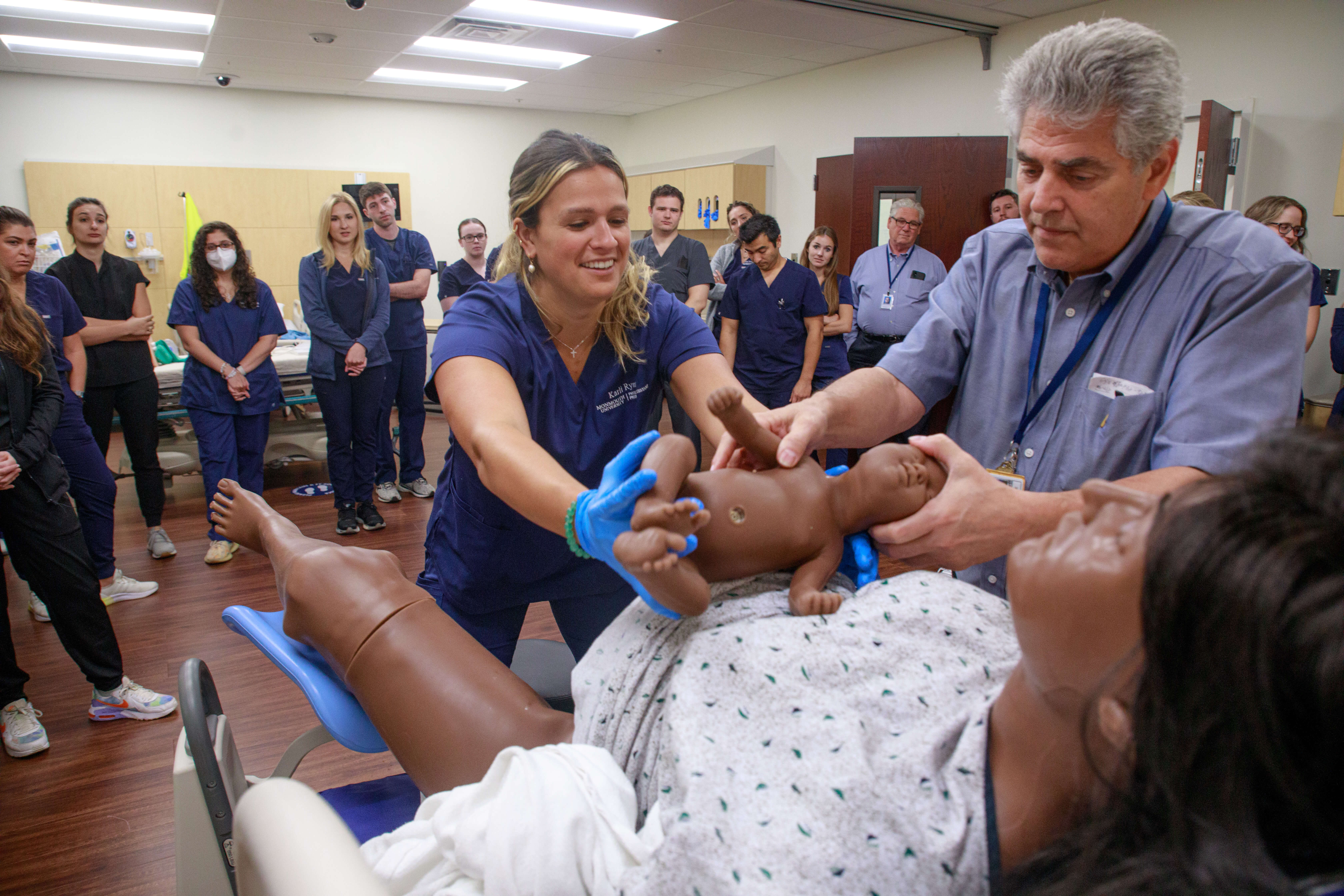 Dr. Robert Massaro assists PA students in birth simulation