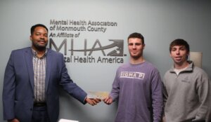 Sigma Pi members present check to Mental Health Assn