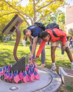 We remember. 🇺🇸 #MonmouthU came together at our 9/11 Memorial to honor the heroes and those we lost. Over 200 flags were placed, a powerful symbol of resilience. This memorial, featuring a piece of the World Trade Center gifted by Lewis & Judith Eisenberg in 2011, stands as a lasting tribute.🗽 #NeverForget